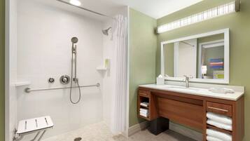 A modern bathroom with a walk-in shower, a vanity with a mirror, and a towel rack.