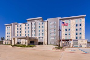 Hampton Inn & Suites offers a convenient entrance with a covered walkway and parking area.