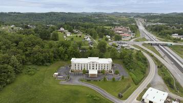 A large building with a parking lot and a highway nearby.