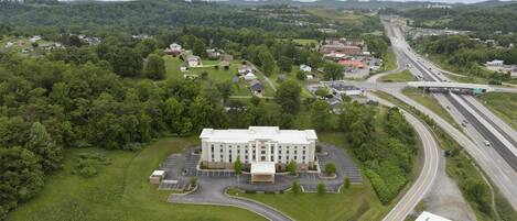 A large building with a parking lot and a highway nearby.