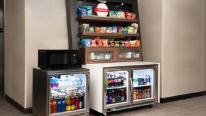Un distributeur automatique de collations, un four à micro-ondes et deux distributeurs de boissons réfrigérées.