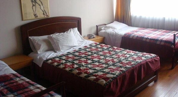A hotel room with two single beds, a wooden headboard, a nightstand, and a bedside table. - Hotel Casa La Embajada Colonial (Bogotá)