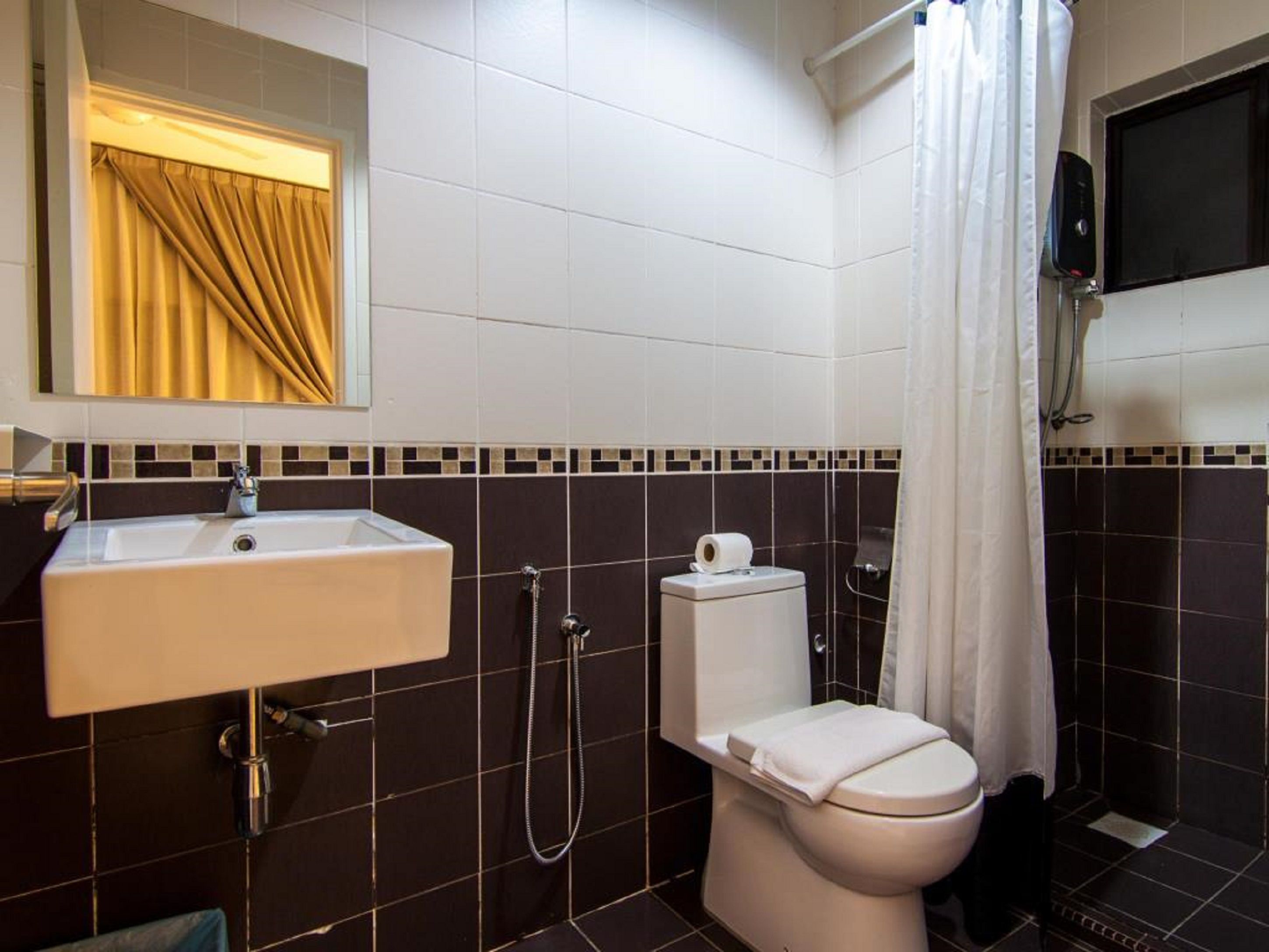 A bathroom with a white sink, toilet, and shower.