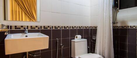 A bathroom with a white sink, toilet, and shower.