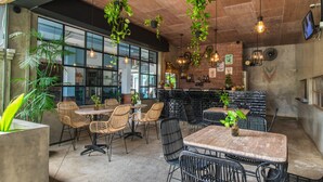 A restaurant with outdoor seating, hanging plants, and brick walls. - Gemini Star Hotel Kuta (Kuta)