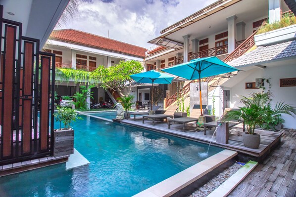 Una piscina al aire libre, sillones reclinables de piscina