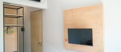 Ein Zimmer mit integriertem Fernseher, einem Holzschrank und einem Kleiderhaken.