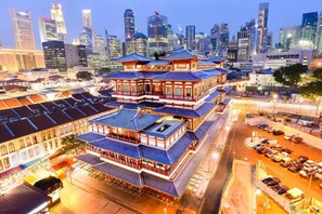 A traditional multi-story building with a distinct architectural style, surrounded by a modern cityscape with skyscrapers. - Hotel 81 Cosy (Singapore)