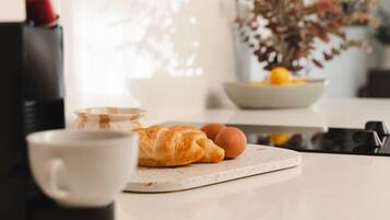 Een aanrecht met een croissant, eieren en een koffiekop.