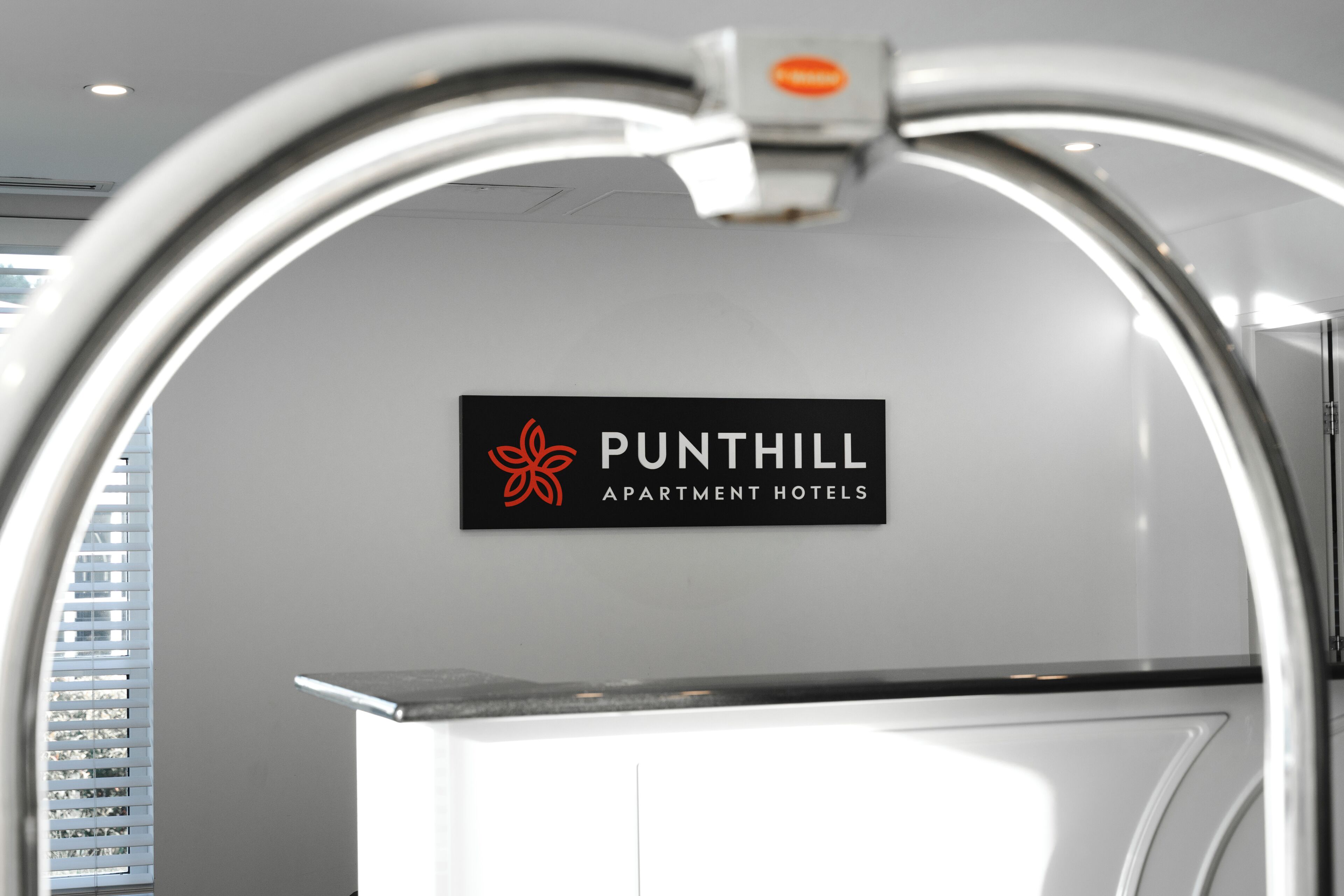 A sign for 'PUNTHILL APARTMENT HOTELS' with a modern design.
