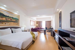 A hotel room with a large bed, a desk with a computer, a television, and a painting on the wall. - Sintesa Peninsula Hotel Palembang (Palembang)