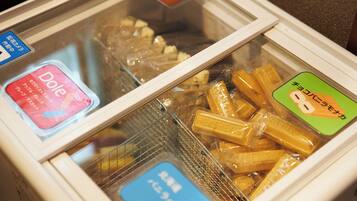A refrigerated display case with various packaged food items, including a visible Dole brand product and a Hershey's chocolate bar.