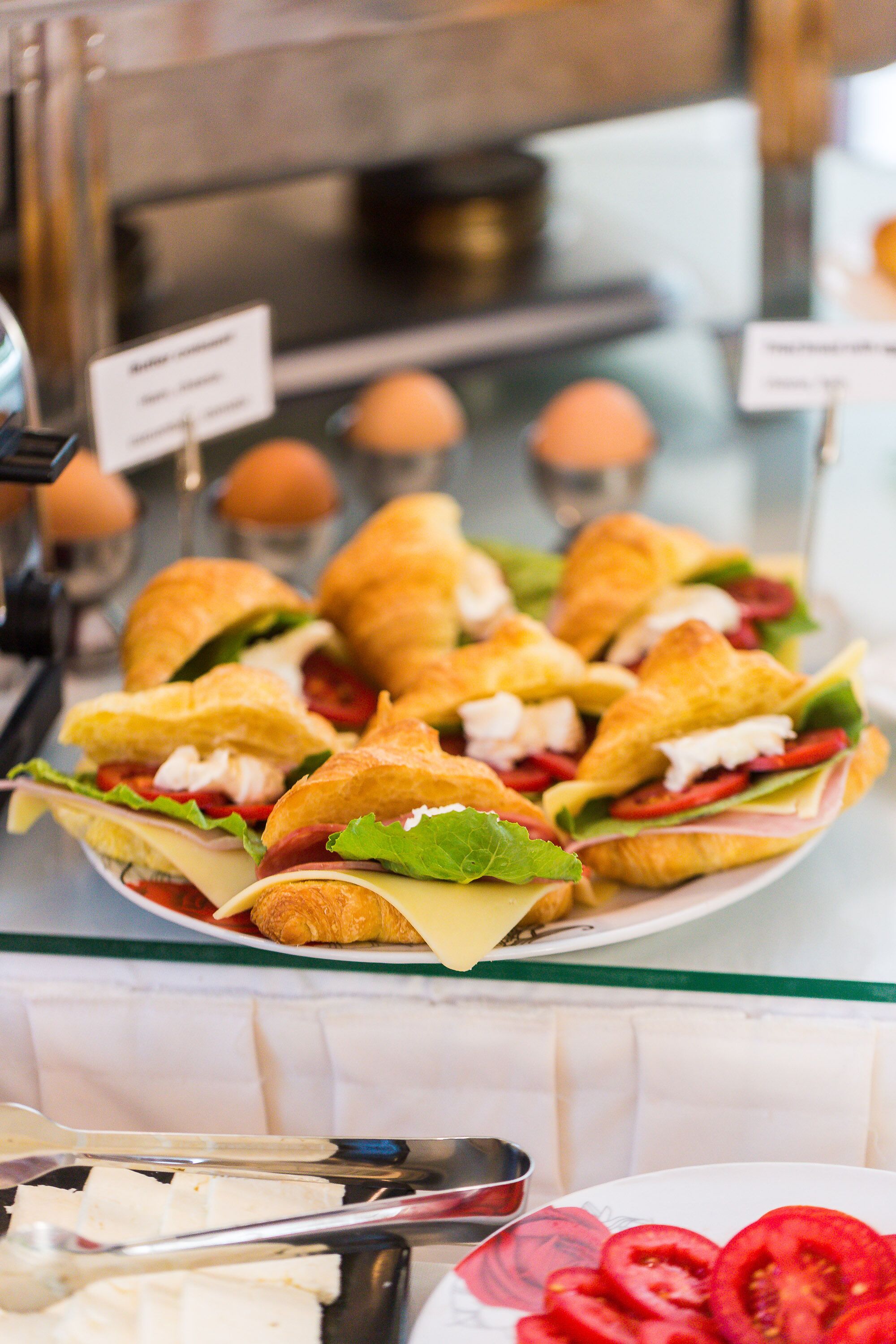 A plate of sandwiches with various fillings, a knife, and a cutting board.