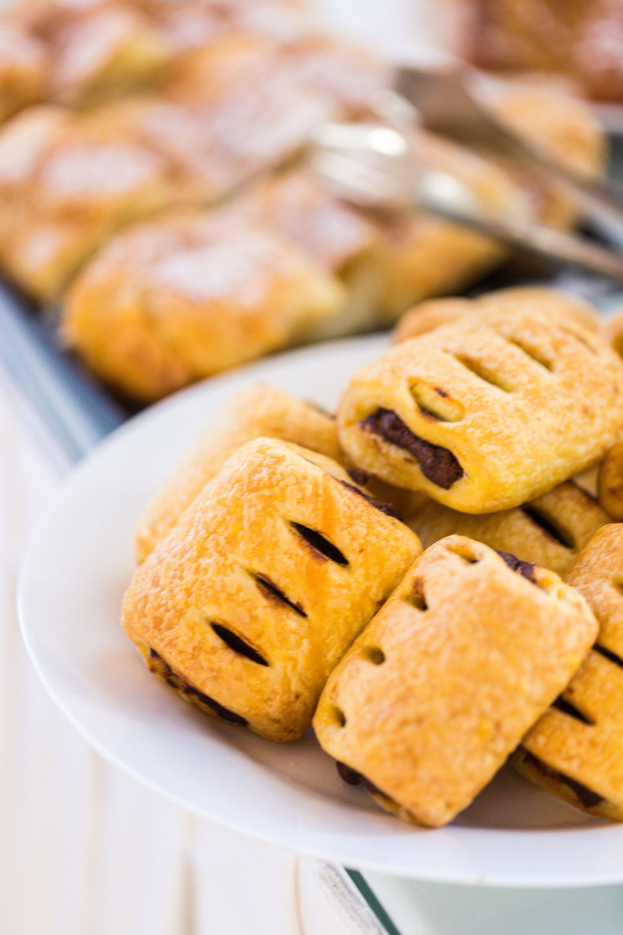 Un plato de pasteles dorados y crujientes, con un diseño de borde ondulado, probablemente dulces.