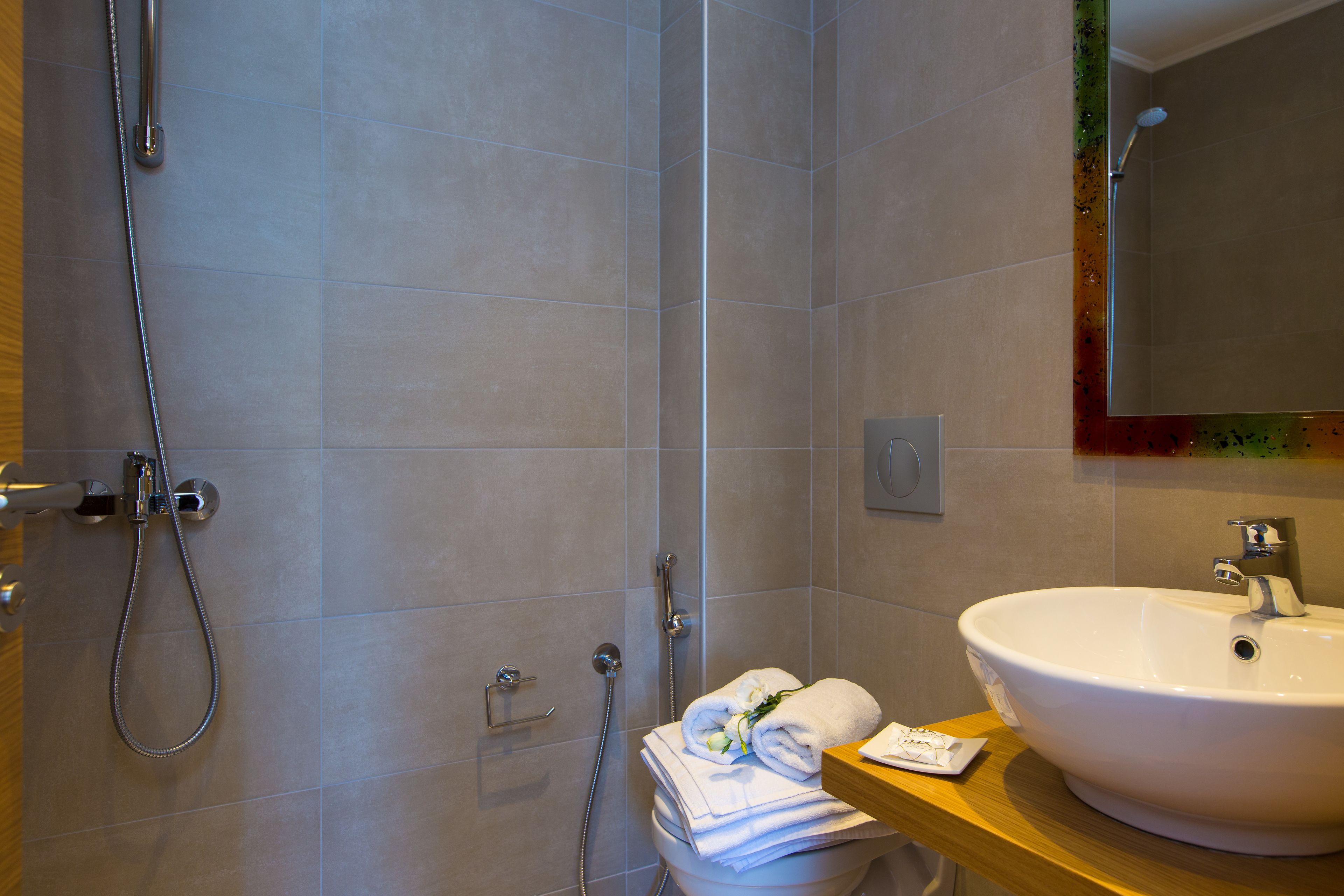 A bathroom with a shower, a sink, and a toilet.