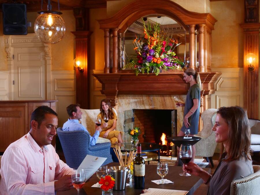 Ein formeller Speisesaal mit Kamin, Holzmöbeln und einer Chandelüster.