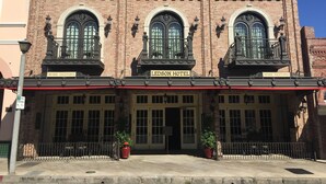 The exterior of the Ledson Hotel with a brick facade, large arched windows, and a sign indicating wine tasting.