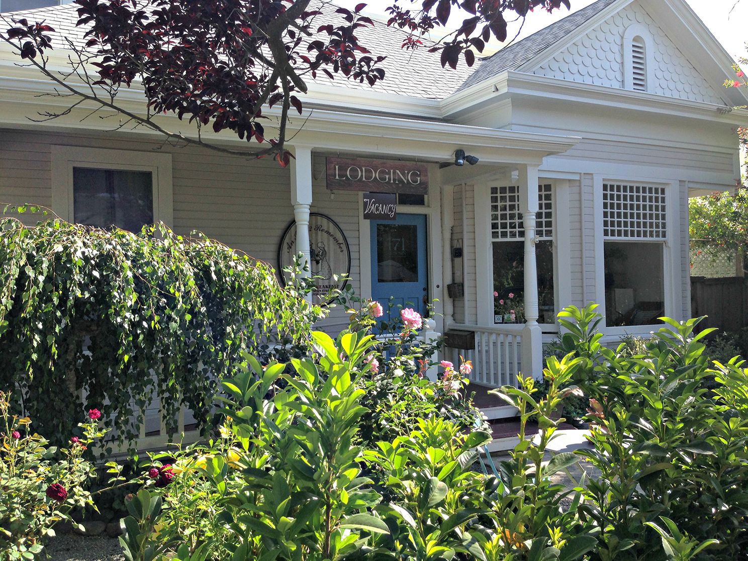 A white building with a blue door labeled "Lodging" and a sign "Viney".