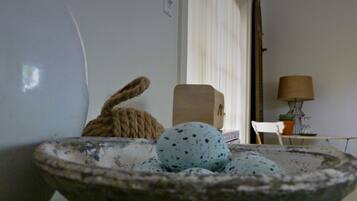A rustic interior with a stone bowl containing eggs, a rope, and a wooden box.