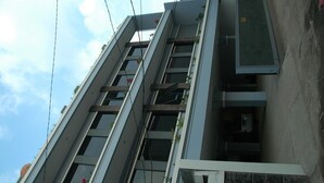 A multi-story building with a modern architectural design, featuring balconies and large windows. - Hotel Unik (Bandung)