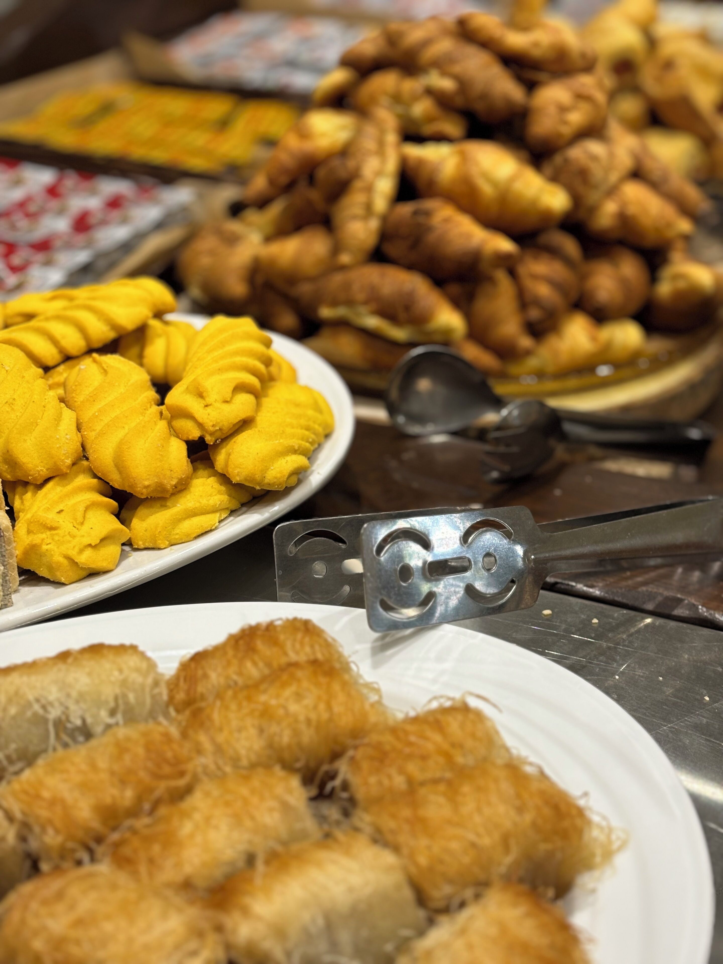 A variety of fried pastries on display, including golden-brown fried dough and yellow fritters.