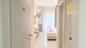 A hotel room with a bed, a desk, a chair, a TV, and a bathroom. - Samel Hotel (Kassandra)