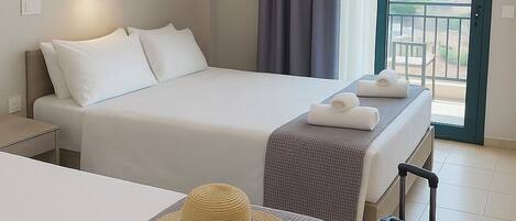 A hotel room with two beds, a balcony, and a suitcase.