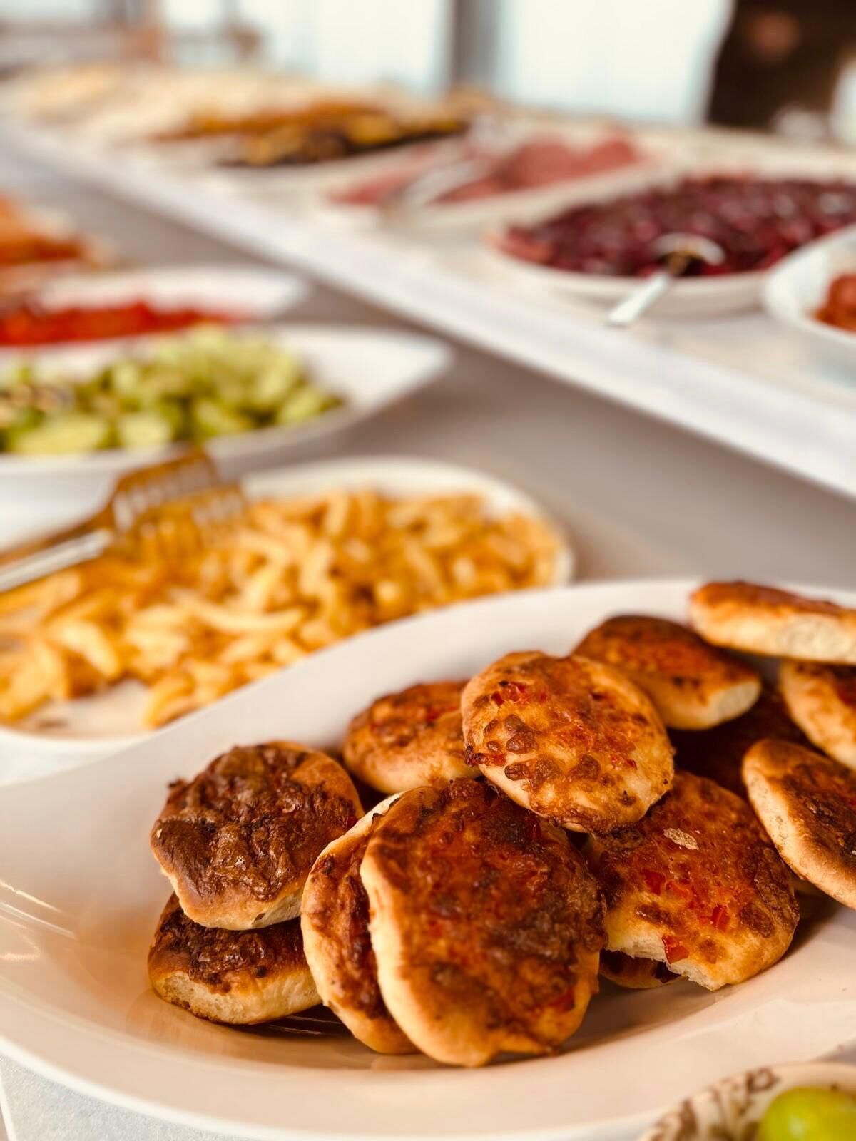 Ein Buffet mit verschiedenen Speisen, darunter gegrillte Gerichte und eine Portion Pasta.