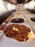Un bufé con diversos alimentos, entre ellos aceitunas, quesos y carnes.