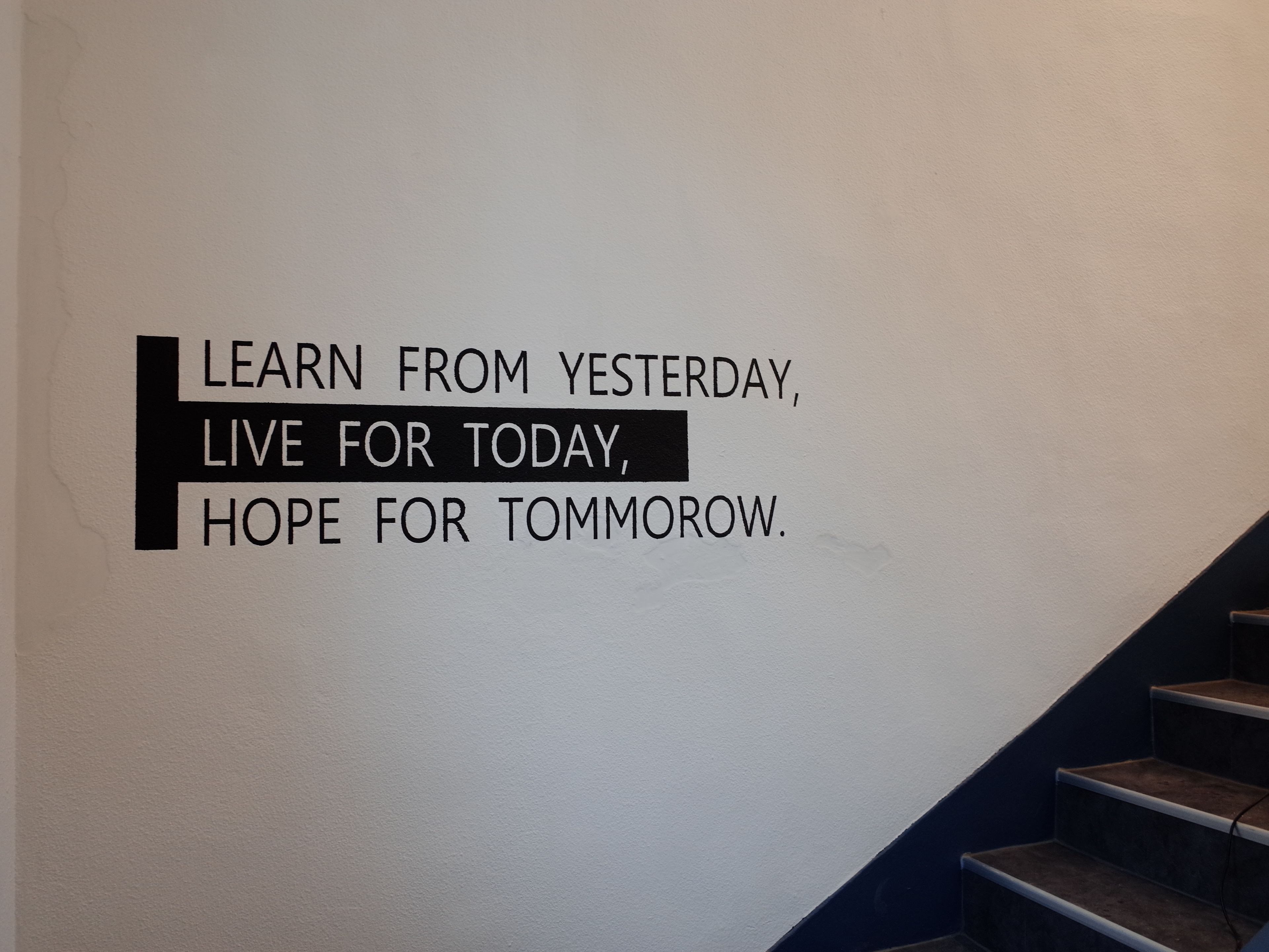 A motivational quote on a wall in a stairwell.