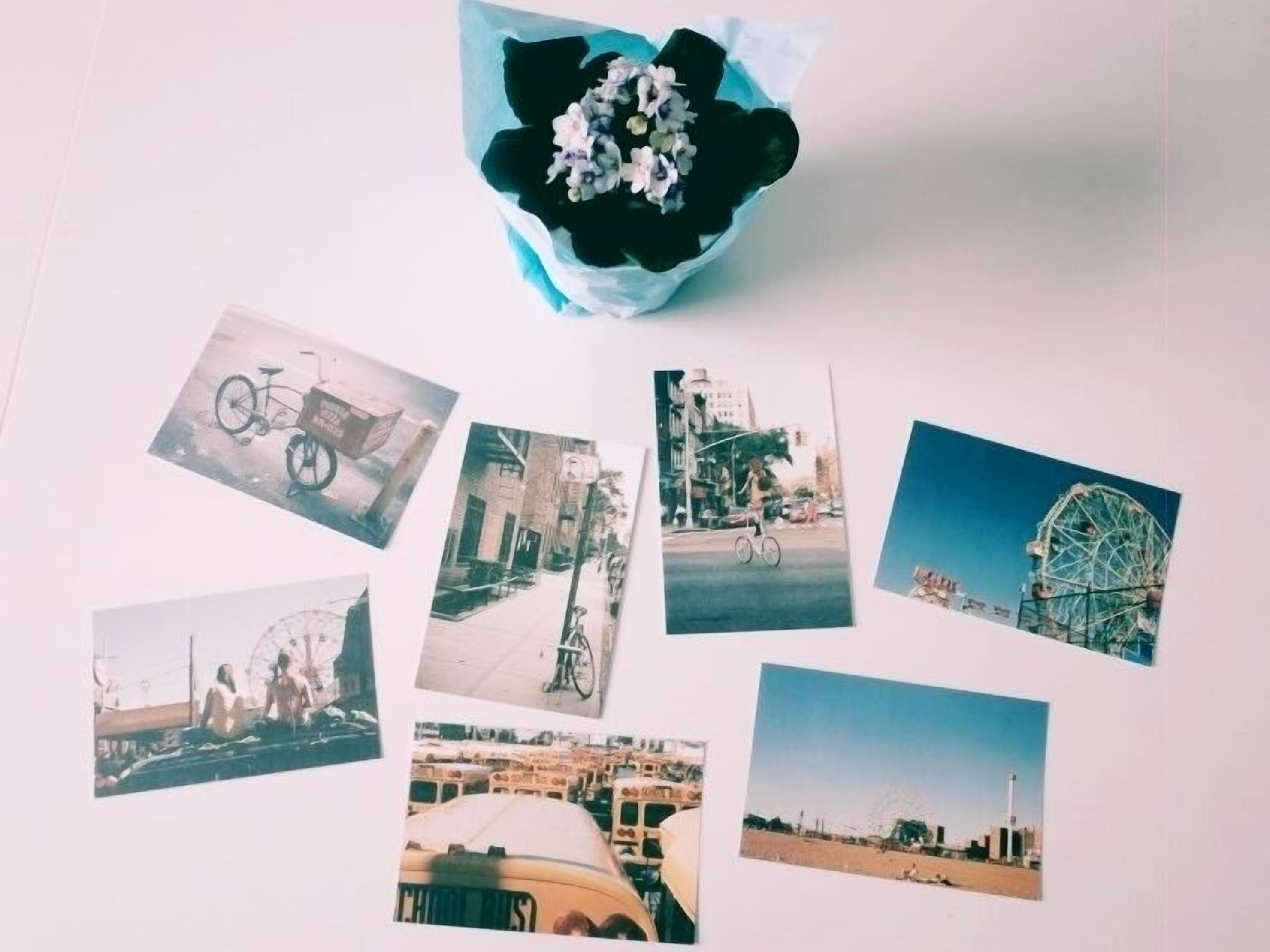 A collection of photographs on a white surface, including a bicycle, a building, a Ferris wheel, and a rocket launch.