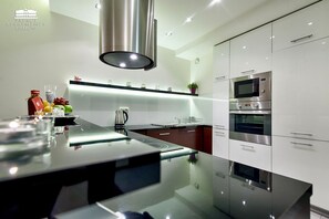 A modern kitchen with a central island, stainless steel appliances, and a sleek design. - Palace Apartments Krakow - Szlak (Kraków)