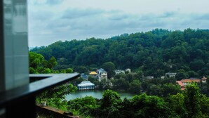 A view of a lakeside village with houses surrounded by dense forest. - Hotel See Kandy (Kandy)