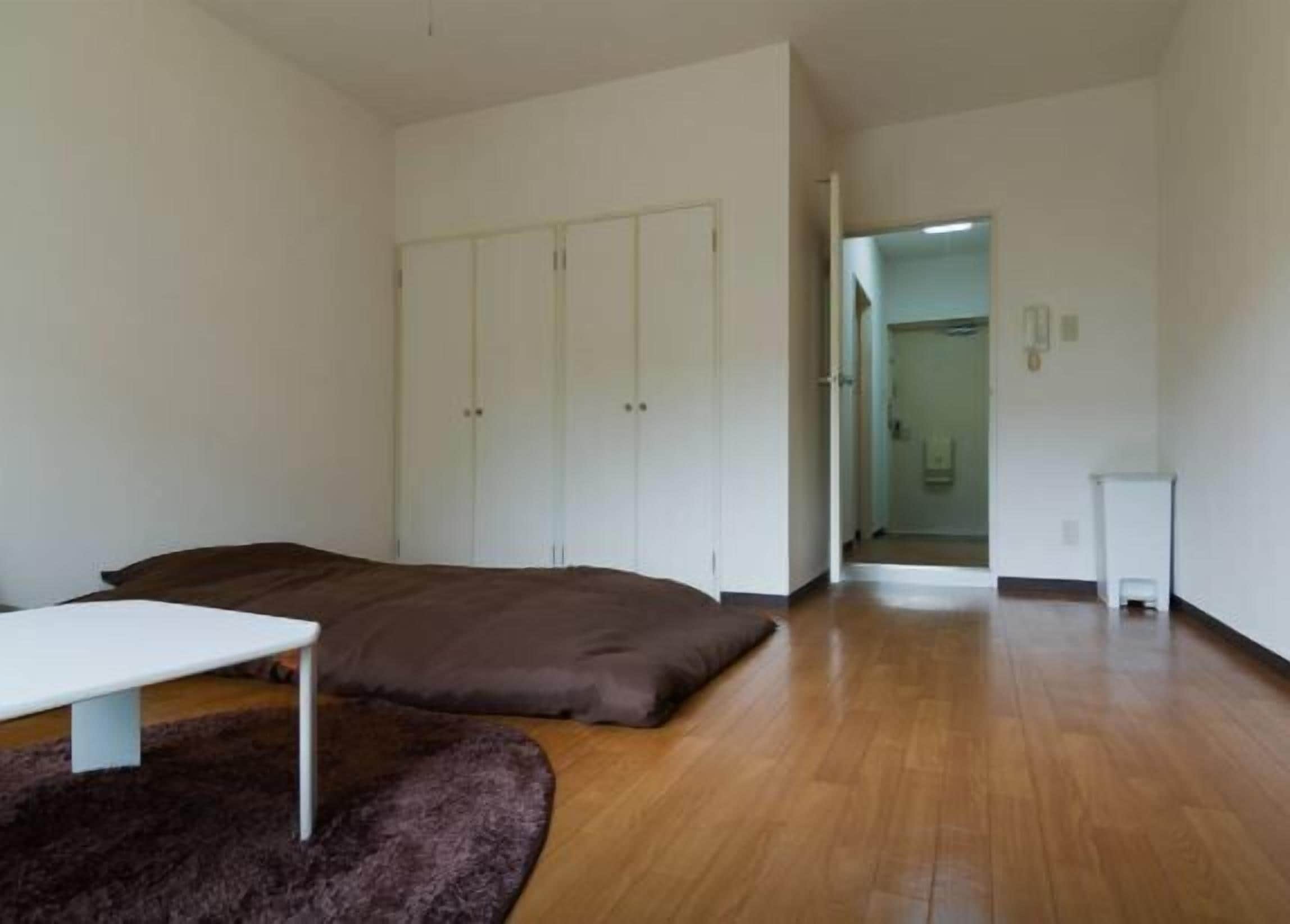 A room with a bed, a small table, and a wardrobe.