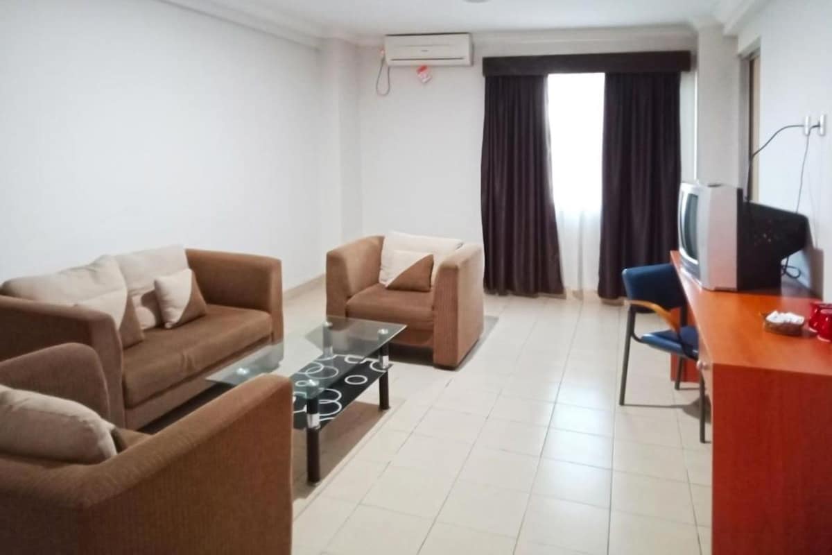 A living room with two sofas, a coffee table, a TV, and a desk.
