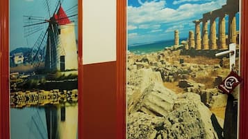 Two doors with artwork depicting a windmill and ancient ruins, both framed in wood.