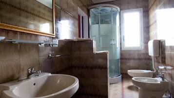 Une salle de bain avec un grand lavabo, une douche à parois de verre et des toilettes.