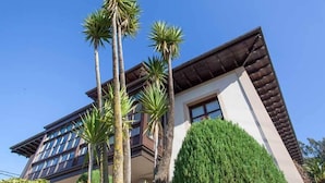 Un edificio de varios pisos con un estilo arquitectónico moderno, que cuenta con grandes ventanales y un techo plano.