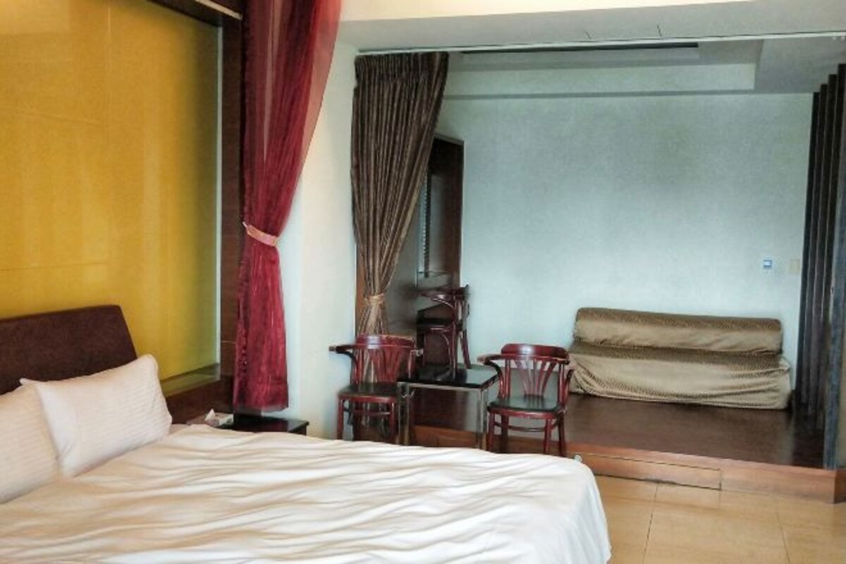 Une chambre d’hôtel avec un lit, un bureau, une chaise et un canapé.