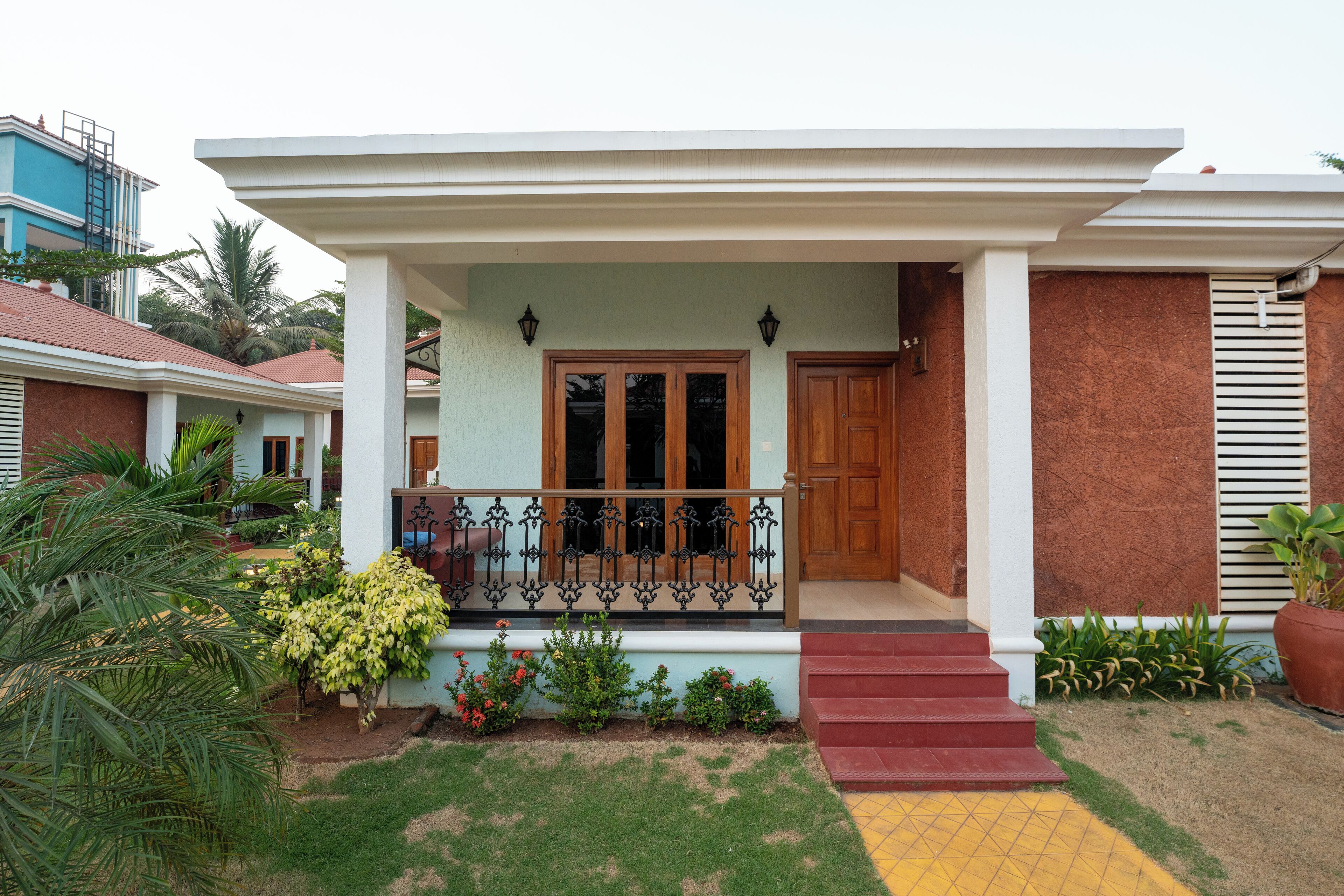 A house with a front porch, a wooden door, and a staircase leading to the entrance.
