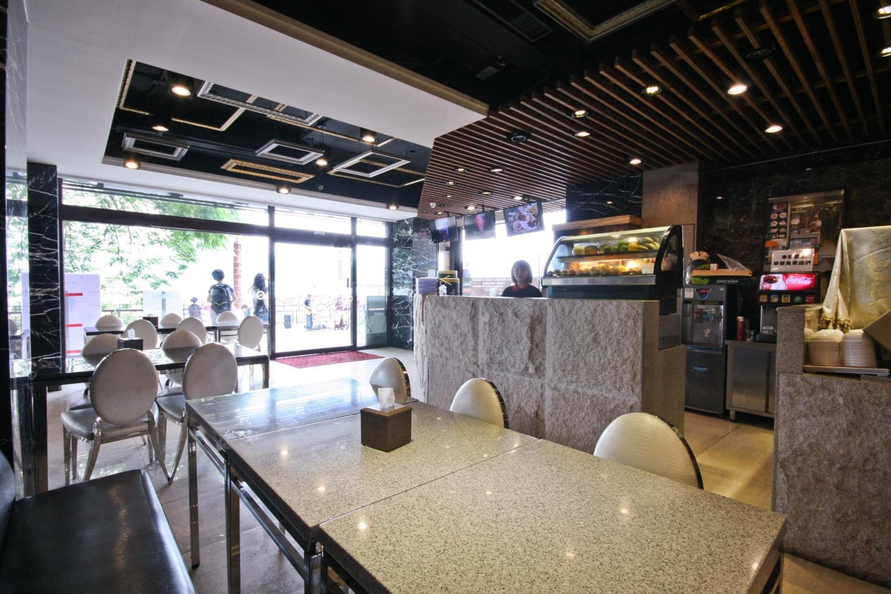 Un interior de restaurante con mostradores de mármol, una isla central y un diseño de techo moderno.