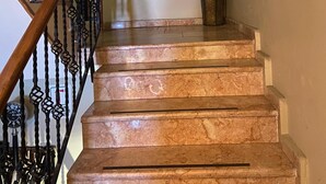 A staircase with marble steps and a black wrought iron railing. - Lena Central Flats (Bursa)