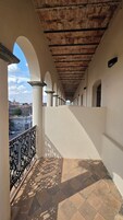 Un pasillo cubierto con arcos, suelo de baldosas y vistas de la ciudad.