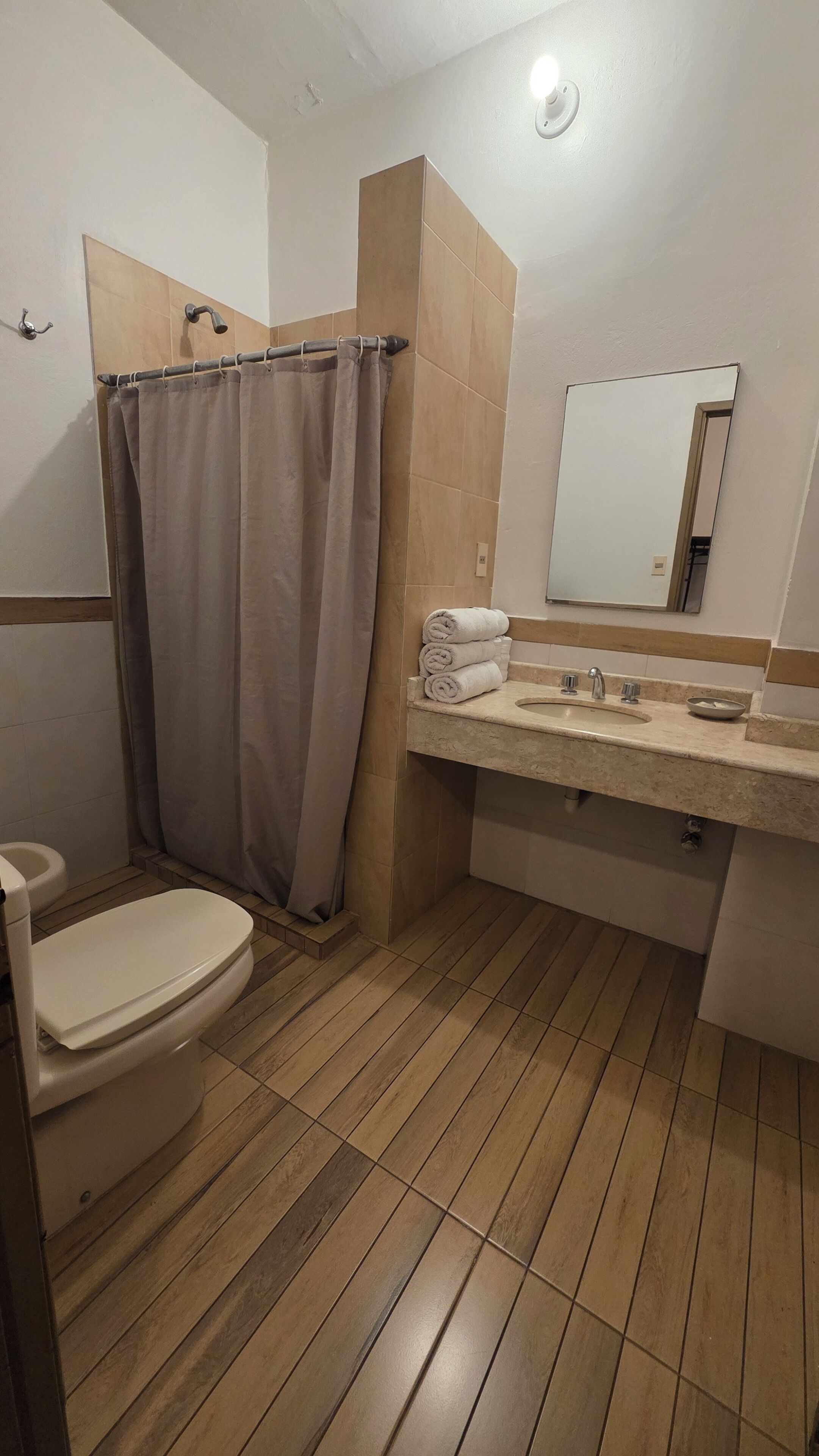 Un baño con inodoro, ducha y lavamanos.