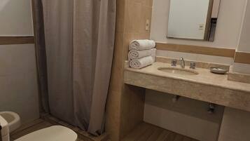 Un baño con inodoro, ducha y lavamanos.