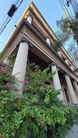 Un edificio de arquitectura clásica, con columnas y un balcón.