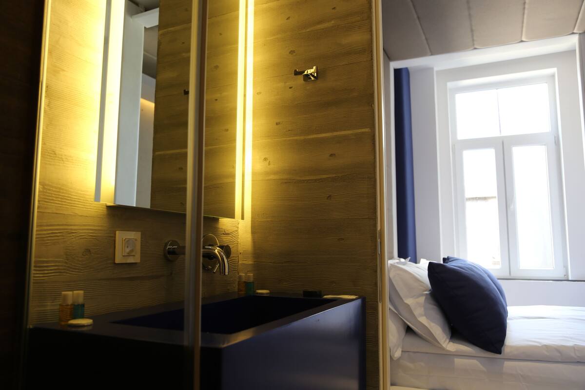Une salle de bain avec un mur en bois, un lavabo et un miroir.