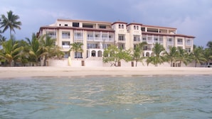A beachfront hotel with multiple balconies, palm trees, and a sandy beach. - Beach Palace Cabarete (Cabarete)