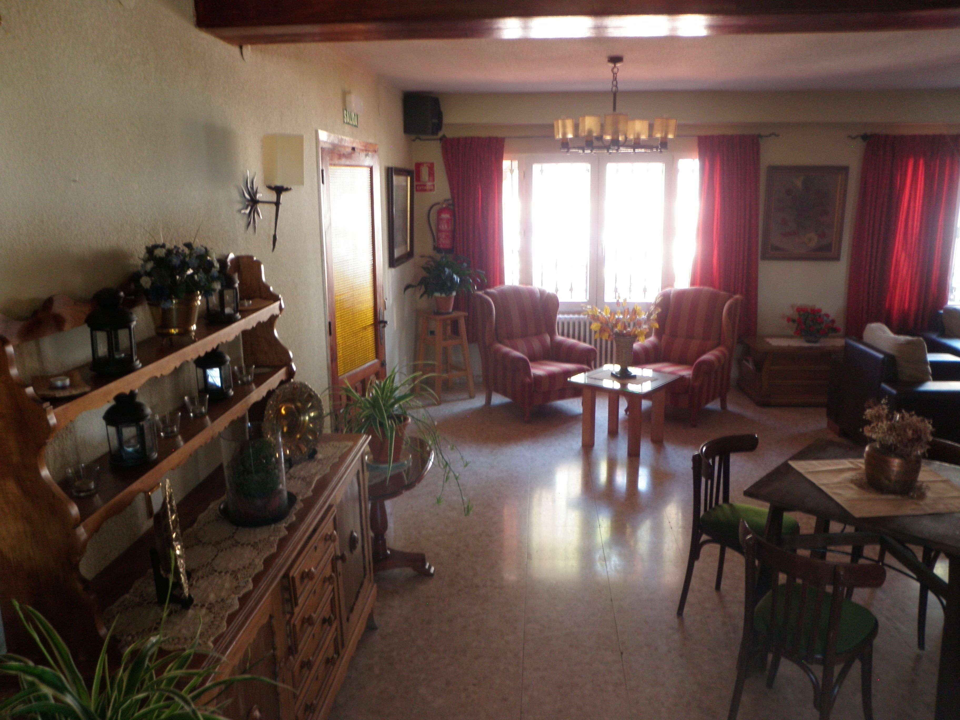 Una sala de estar con chimenea, una mesa de comedor y dos sillones.