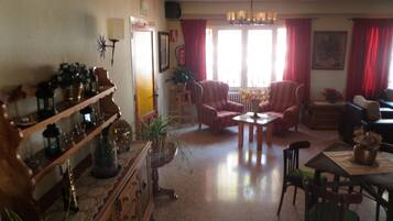 Una sala de estar con chimenea, una mesa de comedor y dos sillones.